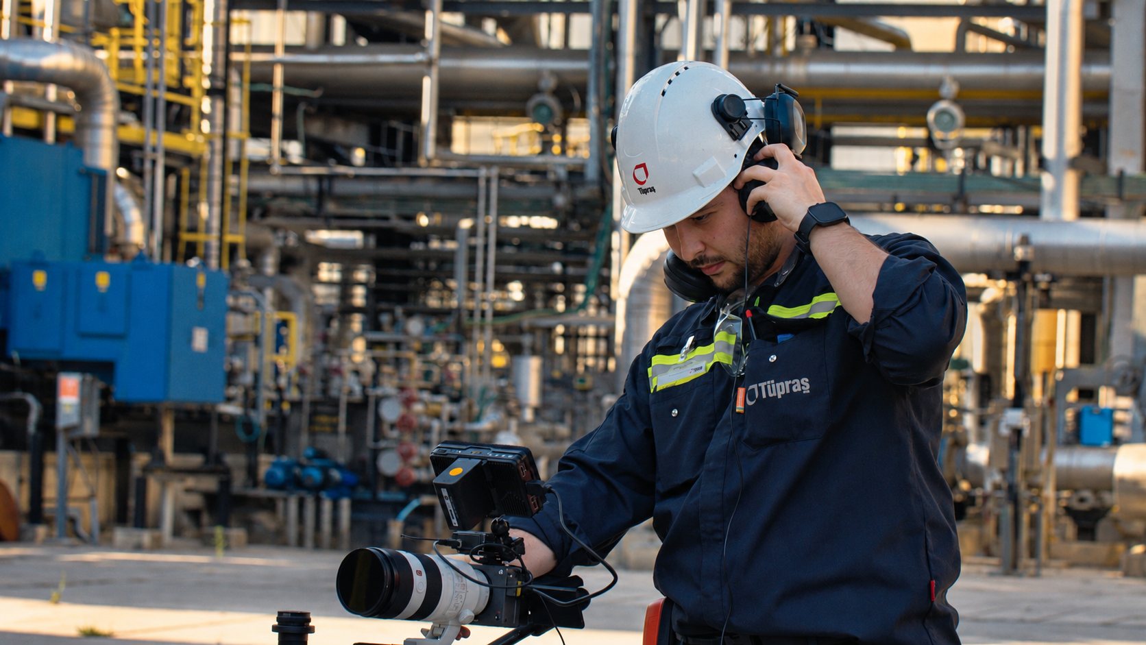 Camera operator in a hard hat with a cinema camera at the Tüpraş refinery